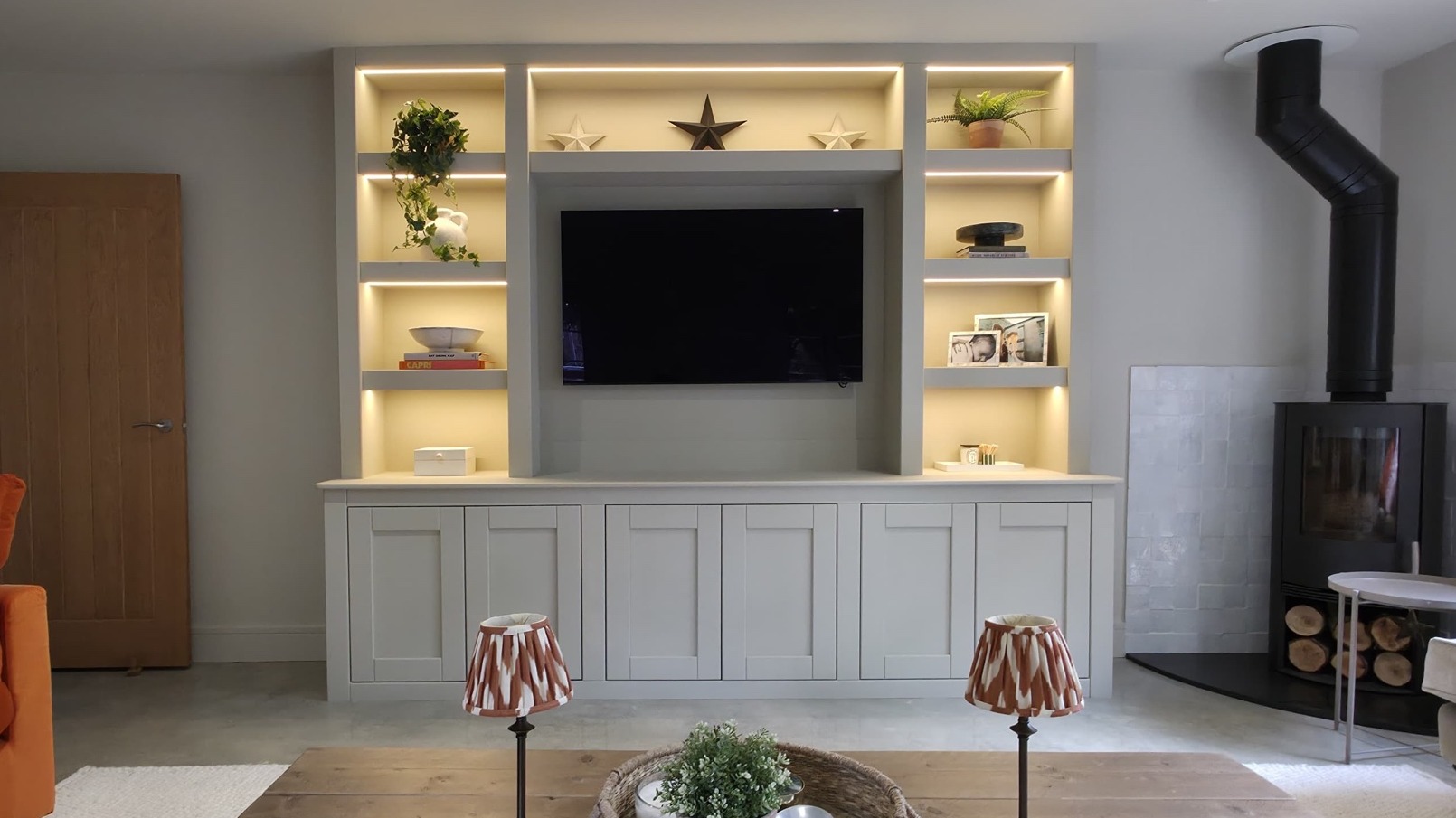 Bespoke media wall with built-in shelving and warm LED lighting, designed and built by Josh Spoore